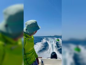 An exciting moment on the water as a person enjoys tubing while being towed by a boat, showcasing the thrill of summer water activities.
