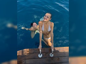 Two friends enjoy a refreshing swim in crystal-clear waters, capturing the essence of summer fun and adventure on the water.