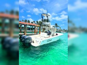 A fishing boat named 'Queen R' is docked in Miami, with crew members preparing for a day on the water — perfect for fishing enthusiasts looking for adventure.