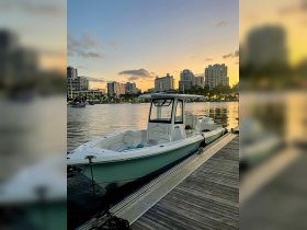 A sleek speedboat docked at sunset, showcasing its elegant design against a backdrop of city lights — perfect for evening cruises.