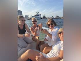A joyful group of friends celebrates on a boat, raising their glasses for a toast — perfect for memorable gatherings and fun boat parties.