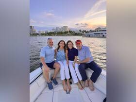 A cheerful group of friends enjoys a sunset boat ride, capturing a memorable moment on the water — perfect for celebrations and gatherings.