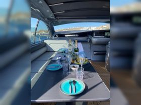 A beautifully arranged dining area on a Pershing 54 yacht, featuring an array of fresh fruits, cocktails, and elegant tableware, perfect for luxurious onboard dining experiences.