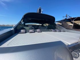 A spacious lounge area on a luxury yacht, featuring comfortable seating and a sleek design, perfect for relaxation on the water.