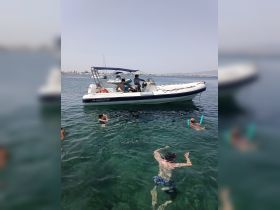 A lively scene featuring a group enjoying a day on the water, with swimmers and a boat in the background — perfect for summer adventures and water activities.