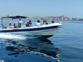 A lively group enjoys a day on the water aboard a speedboat, showcasing the joy of boating adventures along the beautiful coastline.