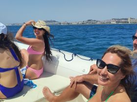 A joyful group of friends enjoys a sunny day on the water, capturing the essence of fun and celebration aboard their boat.