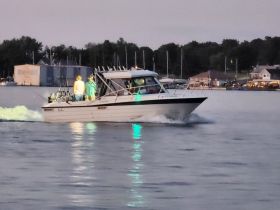 A group of individuals aboard a fishing boat navigate the waters during the evening, showcasing a perfect blend of adventure and camaraderie.