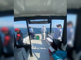 A group of anglers enjoys a day of fishing on a boat, showcasing the camaraderie and excitement of on-water activities.