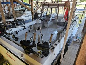 Inside view of a well-equipped boat cabin featuring seating and helm area, perfect for fishing trips or leisurely outings on the water.