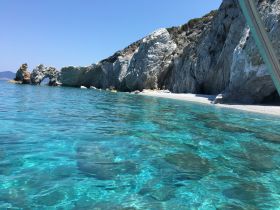 A stunning view of a rocky coastline with crystal-clear waters, perfect for exploring hidden beaches and enjoying the beauty of nature.