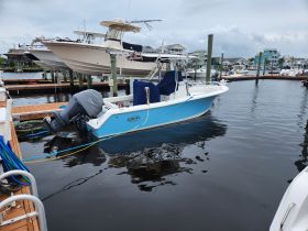A vibrant center console boat docked at the marina, showcasing its sleek design and ready for a day on the water.