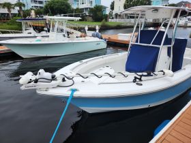 A clear view of a center console boat docked at the marina, showcasing its sleek design and features, perfect for fishing or day trips on the water.