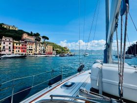 A picturesque view from a sailboat showcasing colorful coastal buildings and serene waters, perfect for capturing the essence of a sailing adventure.