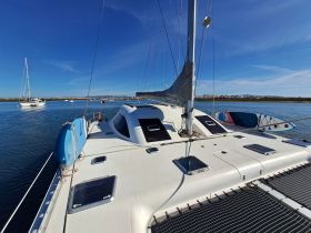 A stunning view of a catamaran cruising through calm waters, showcasing its sleek design and vibrant surroundings — perfect for sailing enthusiasts.