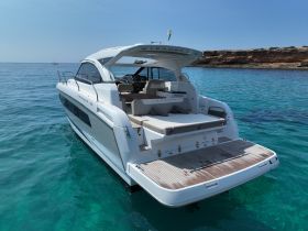 A stunning view of the Leader 36 yacht cruising through crystal-clear waters, showcasing its sleek design and luxurious features.