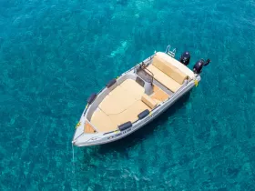 A stunning aerial view of a sleek speedboat gliding over crystal-clear waters, perfect for exploring coastal destinations or enjoying a day on the water.