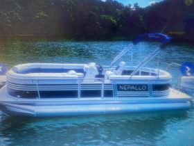 A sleek pontoon boat named 'Nepallo' docked in serene waters, perfect for leisurely outings and family fun on the lake.