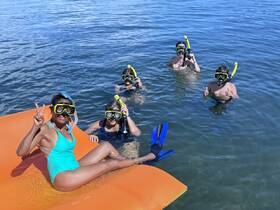 A lively group enjoys snorkeling in clear waters, showcasing fun and adventure in a tropical setting.