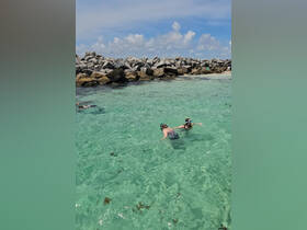 Two children enjoy snorkeling in crystal-clear waters, exploring the vibrant marine life — a perfect family adventure in a tropical paradise.