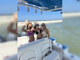 A lively group of friends celebrates on a boat, enjoying a fun day at the beach — perfect for summer outings and memorable adventures on the water.