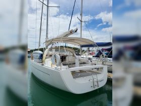 A sleek yacht docked at the marina, showcasing its elegant design and spacious back deck, perfect for leisurely outings on the water.