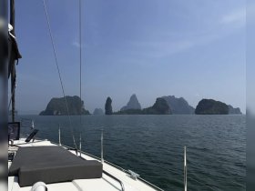 A stunning view from the deck of a sailboat, showcasing dramatic limestone islands against a clear blue sky — perfect for sailing adventures and exploring beautiful coastlines.