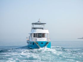 A stunning yacht named 'VOGUE' cruising through calm waters, showcasing its elegant design and smooth sailing capabilities.