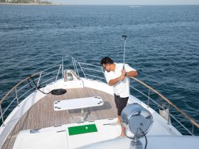 A man prepares to fish from the bow of a boat, showcasing the excitement of a day on the water. Perfect for fishing enthusiasts and adventure seekers.