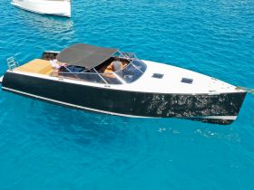 A stylish boat cruising through crystal-clear waters, featuring guests enjoying the ride — perfect for a day of adventure on the sea.