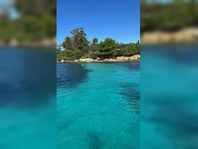 A stunning view of crystal-clear turquoise waters and a lush coastline, perfect for showcasing the beauty of nature during a boating adventure.