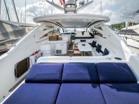 The interior of a luxurious boat features comfortable seating and a spacious lounge area, perfect for relaxing while enjoying the water.