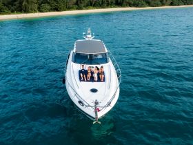 A group of friends relaxes on the deck of a boat, enjoying the sun and the beautiful ocean view — perfect for a day of fun on the water.