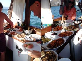 A delicious spread of food laid out on a boat, featuring a variety of dishes perfect for onboard catering during a day at sea.