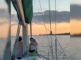 A group enjoys a picturesque sunset while sailing, creating a perfect backdrop for memorable moments on the water.