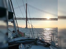 A couple enjoys a romantic sunset sail under the iconic bridge, capturing the perfect moment on the water — an ideal backdrop for unforgettable experiences.