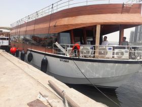 A group of individuals interacts on a boat docked at the marina, showcasing the vibrant atmosphere of boating activities.