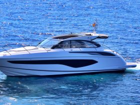 A sleek yacht gliding through crystal-clear waters, showcasing its elegant design and perfect for luxury cruising.