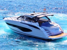 A sleek yacht named 'ASPEN' glides through crystal-clear waters, showcasing its elegant design and perfect for luxurious outings.