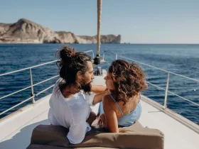 A couple enjoys a romantic moment on the deck of a yacht, surrounded by stunning ocean views — perfect for intimate getaways or sunset cruises.