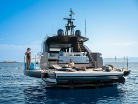 A couple enjoys a relaxing day on a luxurious yacht, sipping drinks and sunbathing on the deck — an ideal setting for summer getaways and romantic escapes.