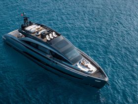 A stunning aerial view of a sleek yacht cruising through crystal-clear waters, showcasing its elegant design and luxurious features.