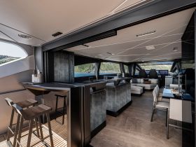A sleek and modern interior view of a luxury yacht's cabin, featuring stylish seating and a well-equipped helm, perfect for comfortable cruising.