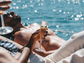 A couple enjoys a relaxing day on the water, sipping cocktails and soaking up the sun — the perfect setting for a luxurious boating experience.