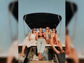 A fun group of friends enjoys a sunny day on a boat, showcasing the perfect atmosphere for celebrations and memorable outings on the water.