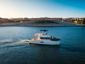 A scenic view of a boat cruising through the water with a vibrant cityscape in the background, perfect for exploring urban waterways.