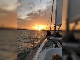 A beautiful sunset view from a sailing boat, with guests enjoying the scenic moment — perfect for romantic outings or group celebrations on the water.