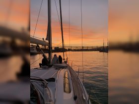 A group enjoys a stunning sunset aboard a yacht, creating a perfect backdrop for memorable sailing experiences.