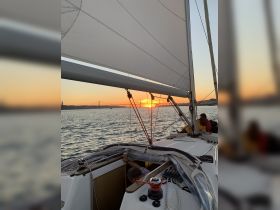 A beautiful sunset view from a sailing boat, capturing a group enjoying the serene waters — perfect for memorable sailing experiences.