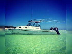 A sleek Twin Vee catamaran anchored in clear turquoise waters, showcasing its elegant design against a vibrant blue sky — perfect for a day of adventure on the water.